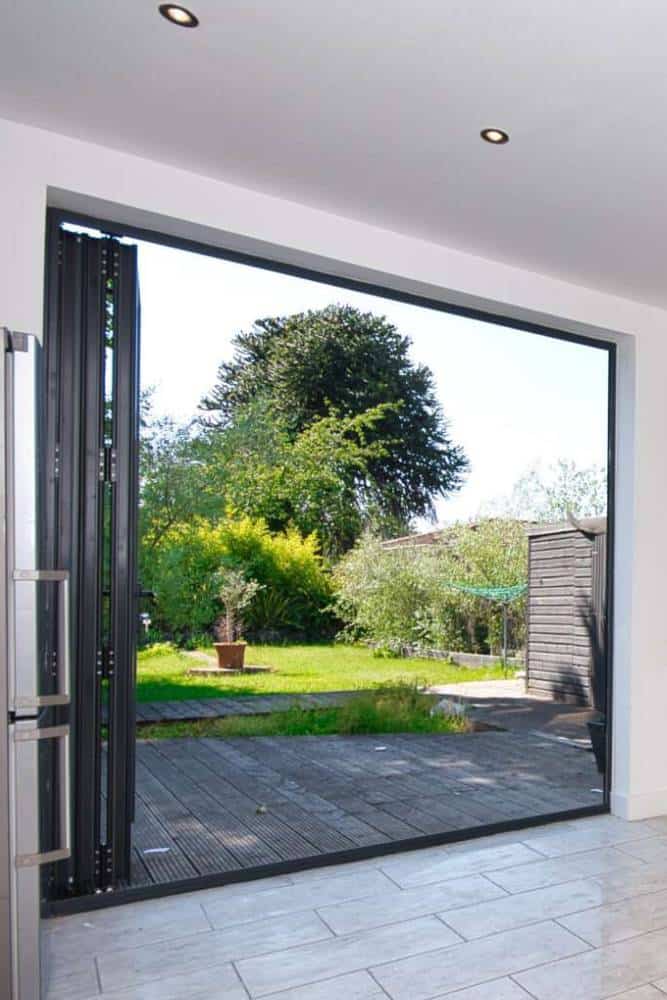 Open bi-fold doors leading to serene garden.