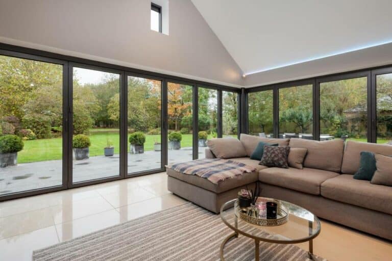 Modern living room with large garden view windows.