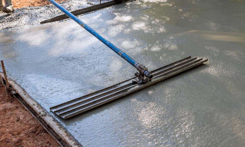 Wet concrete leveling with bull float tool.