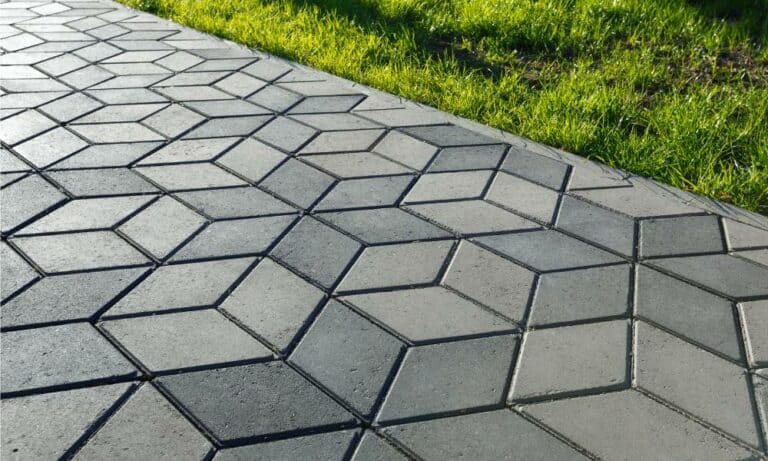 Paved footpath with hexagonal tiles beside grass.