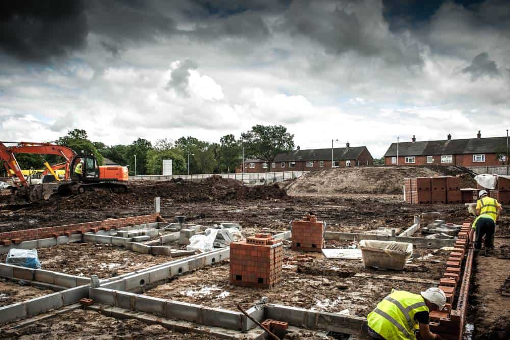 Construction site with workers laying building foundations.