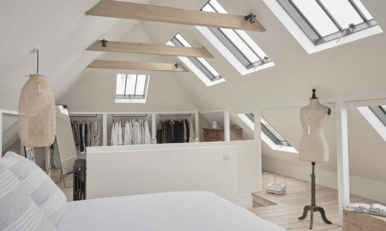 Modern attic bedroom with skylights and minimalist decor.