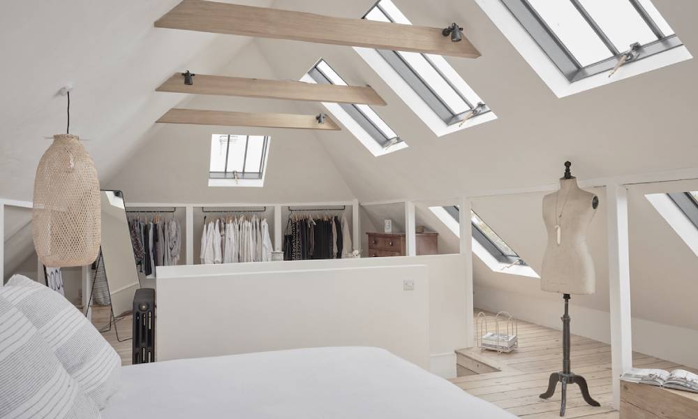 Modern attic bedroom with skylights and minimalist decor.