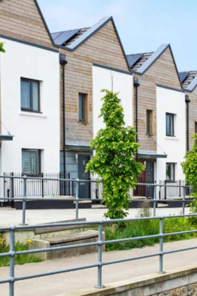 Row of modern townhouses with solar panels.