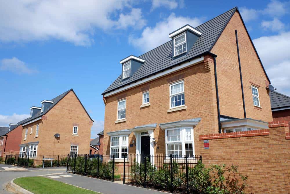 New British detached homes under blue sky.