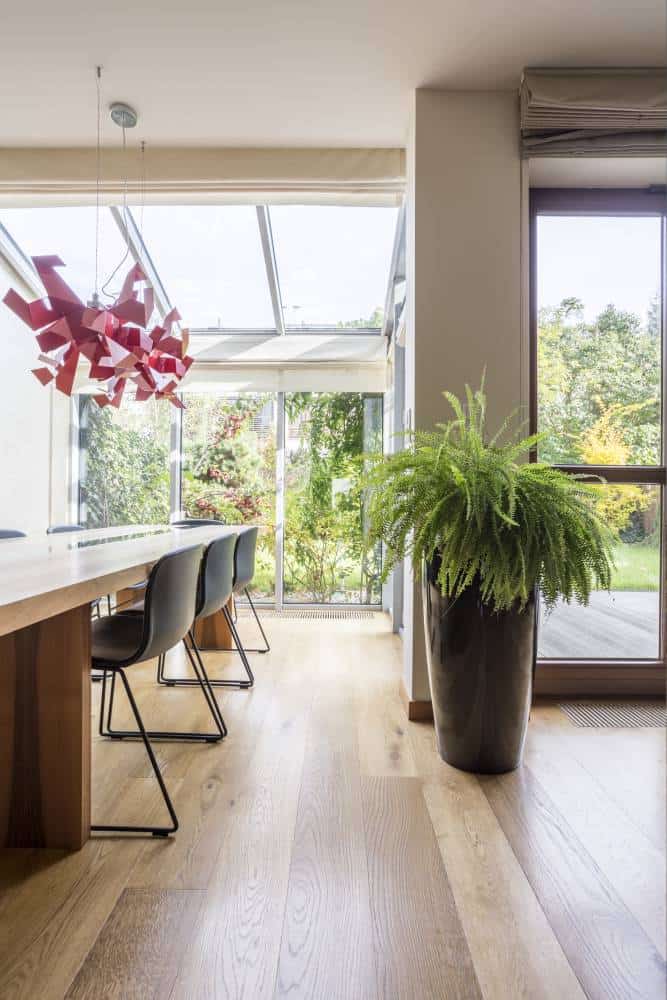 Modern dining room with large windows and garden view.