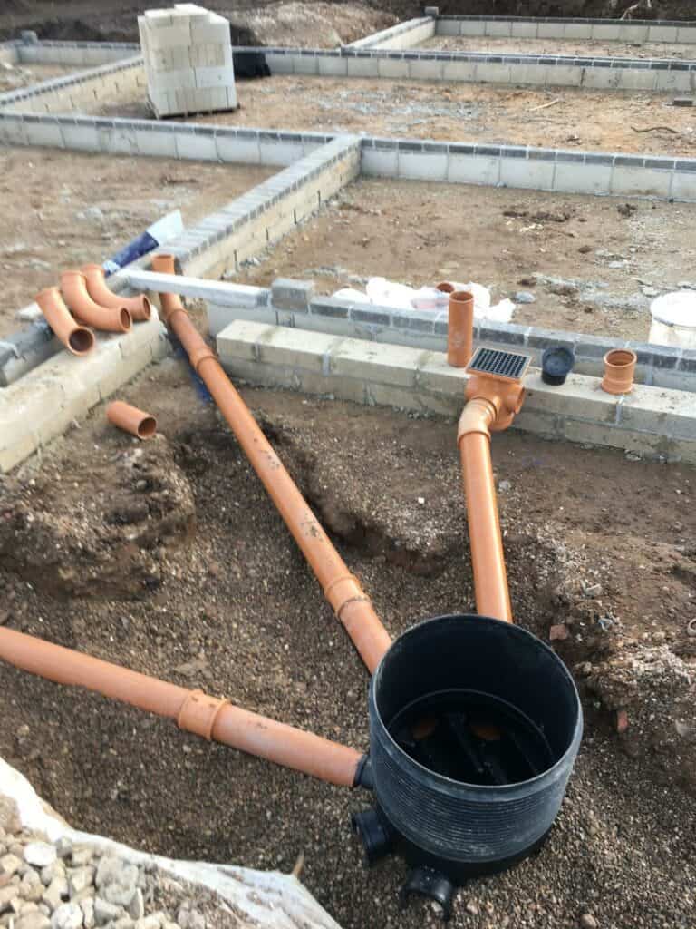 Early-stage construction site with drainage pipes installed.