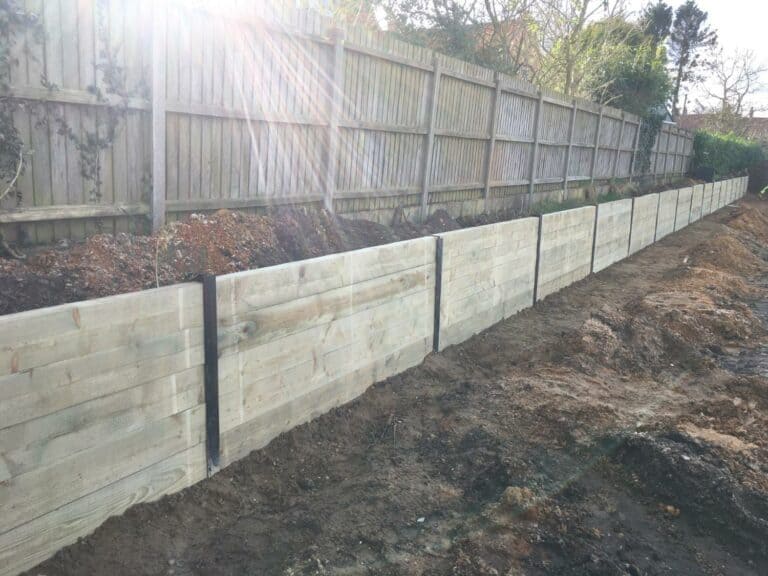 New wooden retaining wall in garden construction.