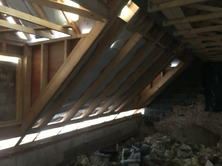 Attic under construction with exposed wooden beams.