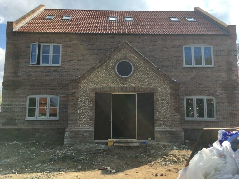 New brick house construction site with scaffolding.