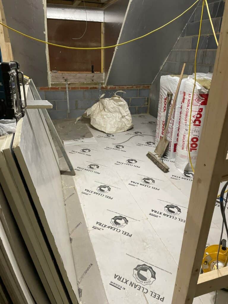 Construction site with drywall installation in progress.