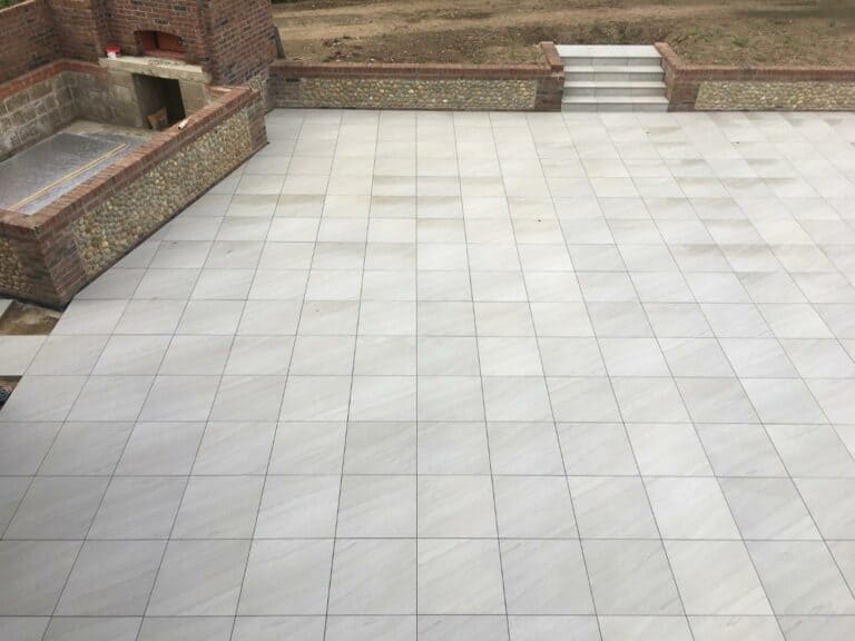 Newly tiled outdoor patio with built-in barbecue and steps.