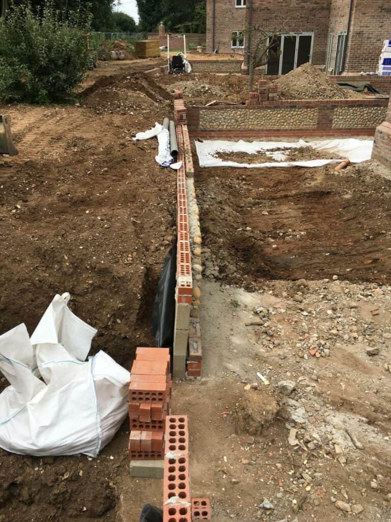 Construction site with foundation trenches and brickwork.