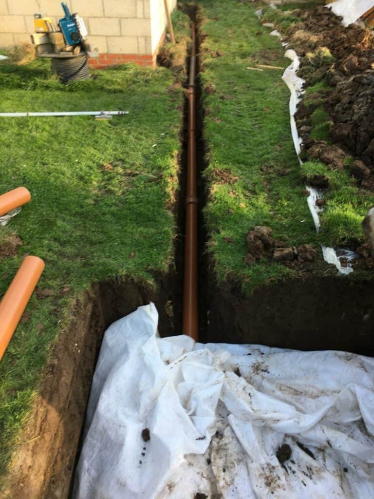 Underground pipe installation in garden trench