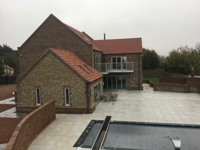 Modern brick house with tiled roof and patio.