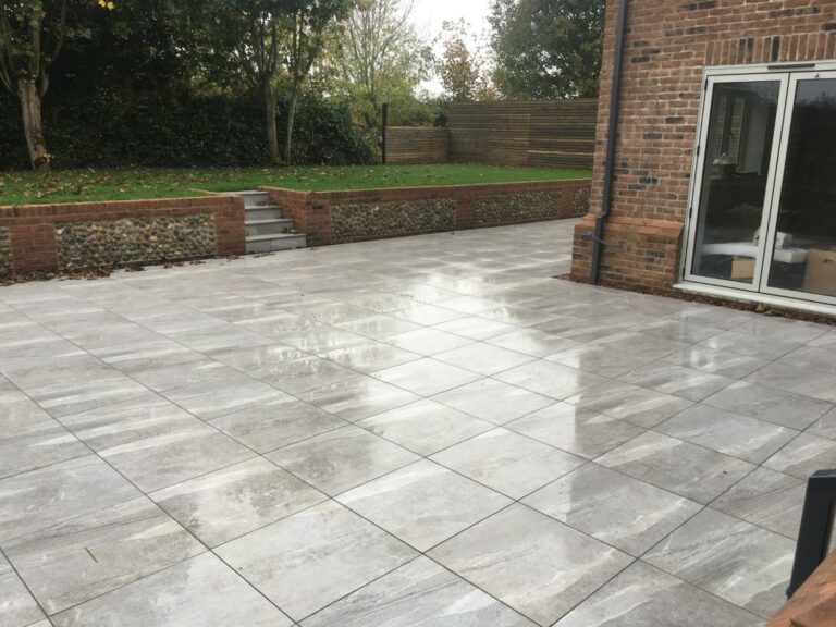 Paved patio garden with wet tiles and brick steps.