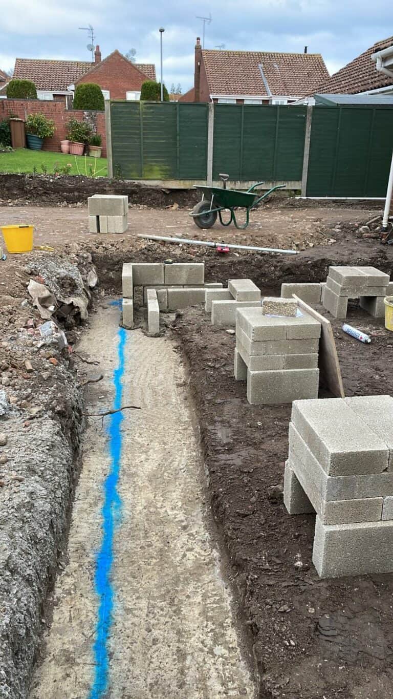 Backyard construction, digging, cinder blocks, wheelbarrow.