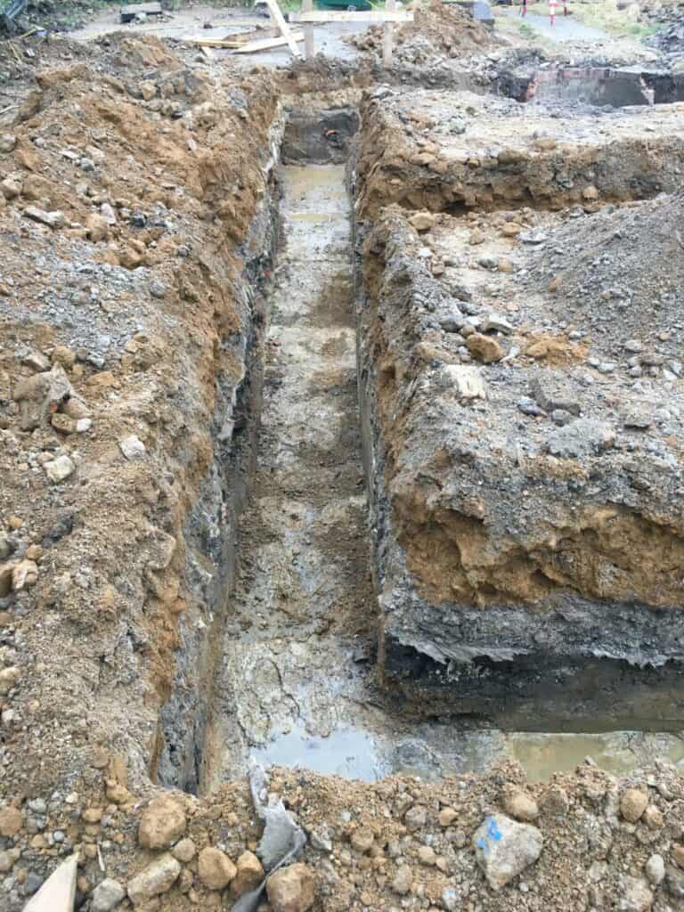 Excavated foundation trenches at construction site.