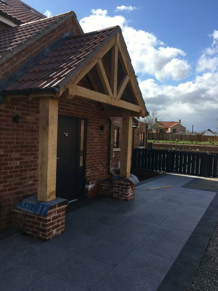 New brick house with wooden porch under construction