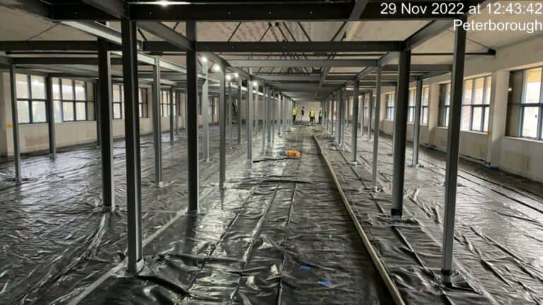 Interior construction site with metal framework and plastic sheeting