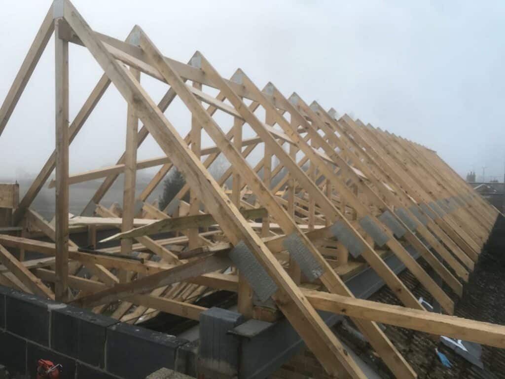 Wooden roof truss construction in progress.