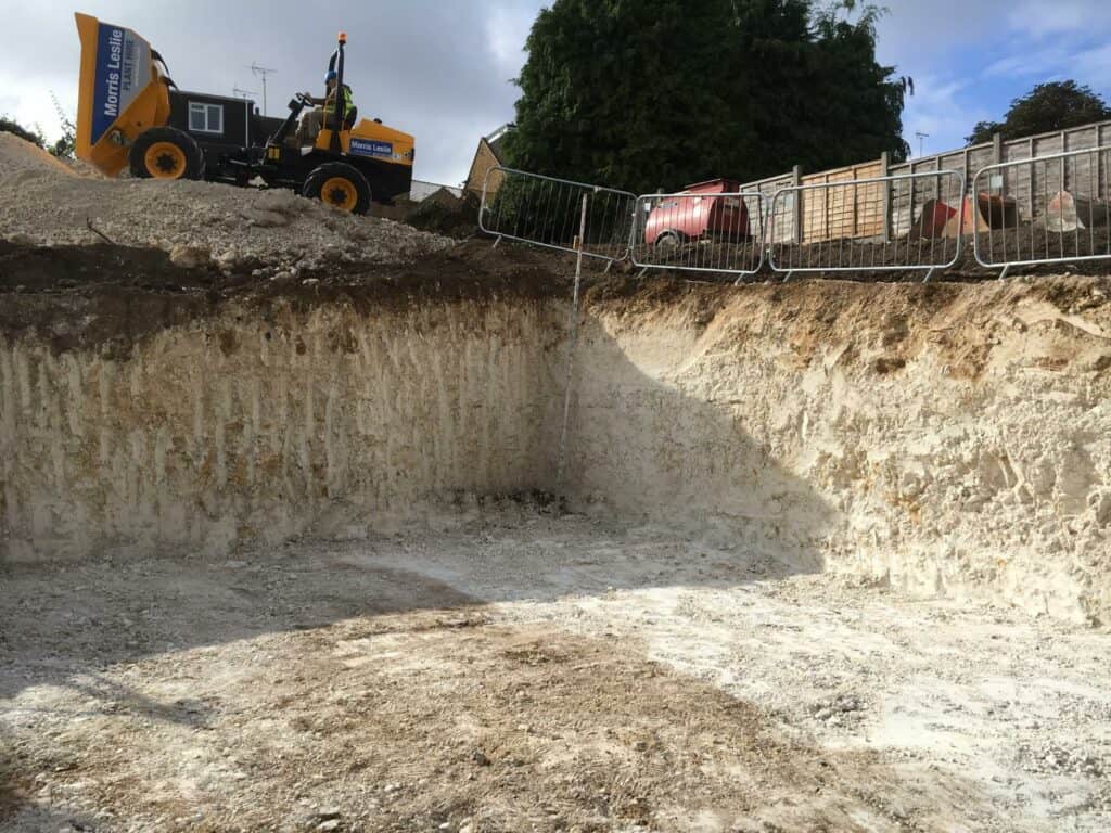 Construction site with excavator and temporary fencing.