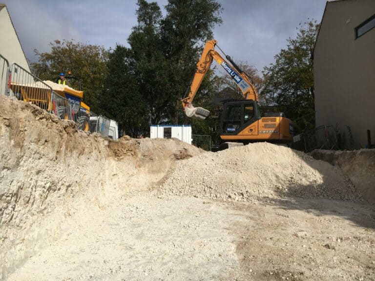 Excavator working at construction site with worker.