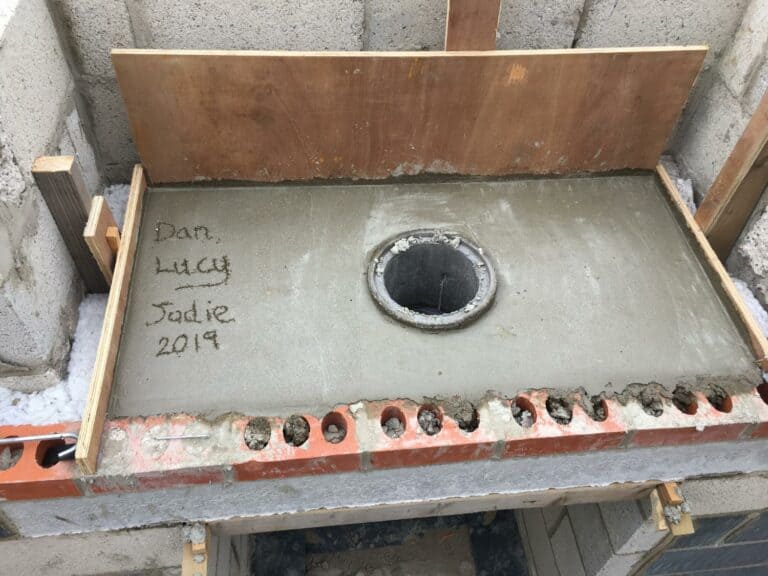 Fresh concrete with names and year written.