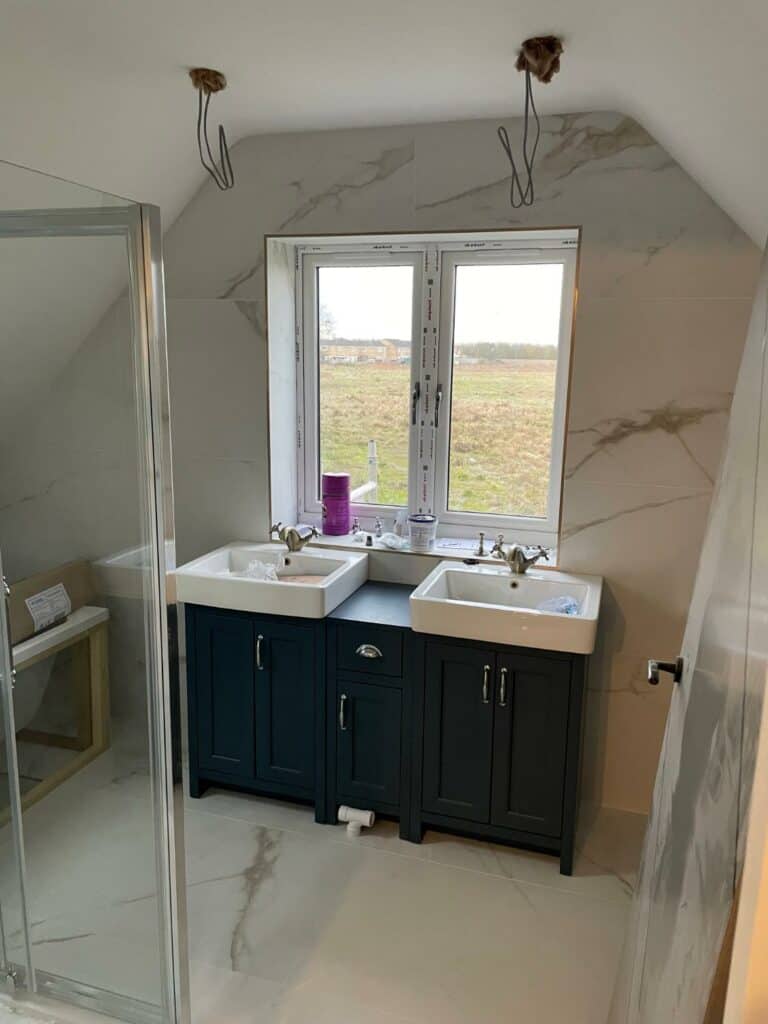 Modern bathroom with double vanity and marble tiles.