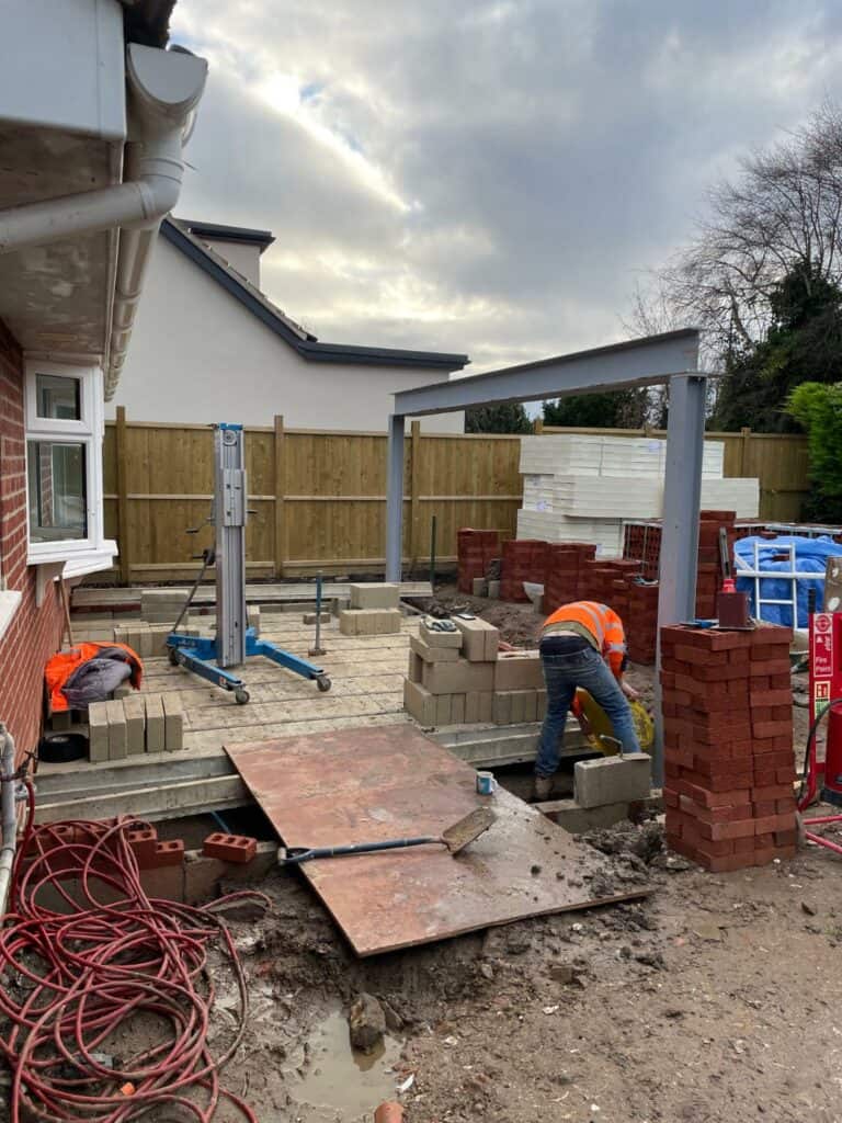 Construction workers building house extension in UK.