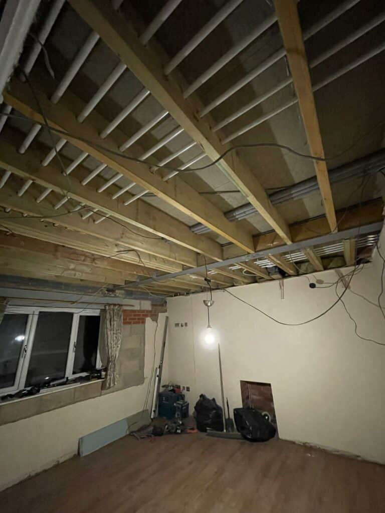 Unfinished attic room with exposed beams and tools.