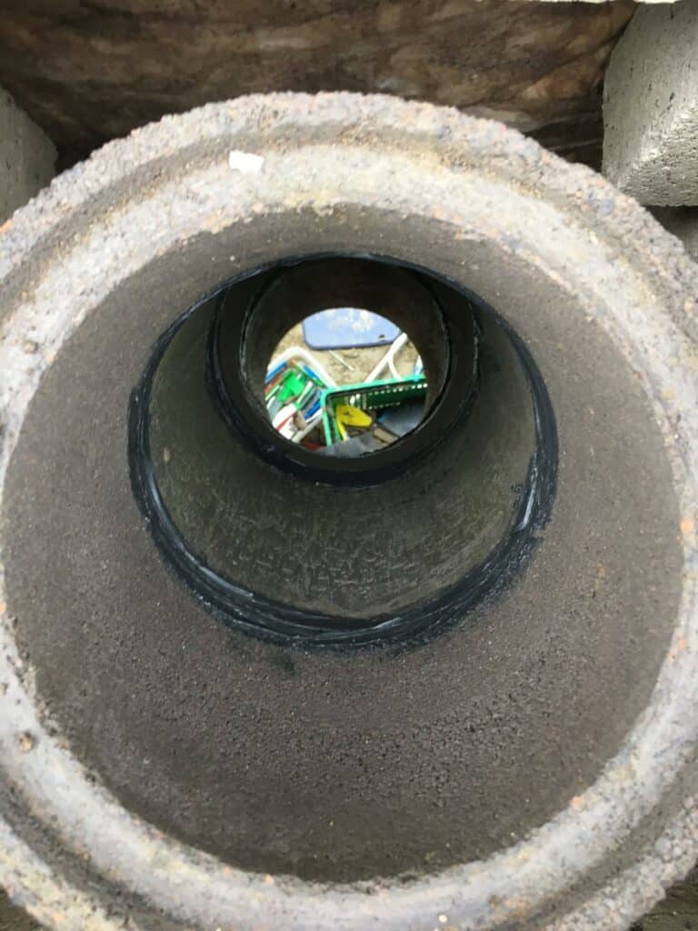 Peering through a concrete pipe onto playground.