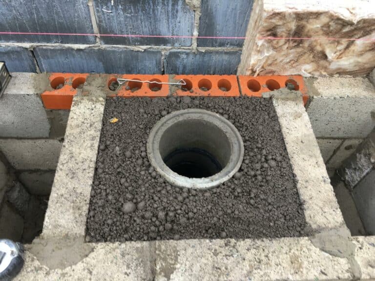 Construction of manhole with concrete blocks and pipes.