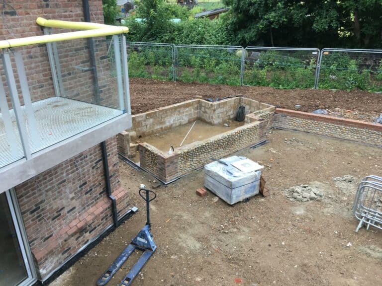 Construction site with incomplete balcony and brickwork.