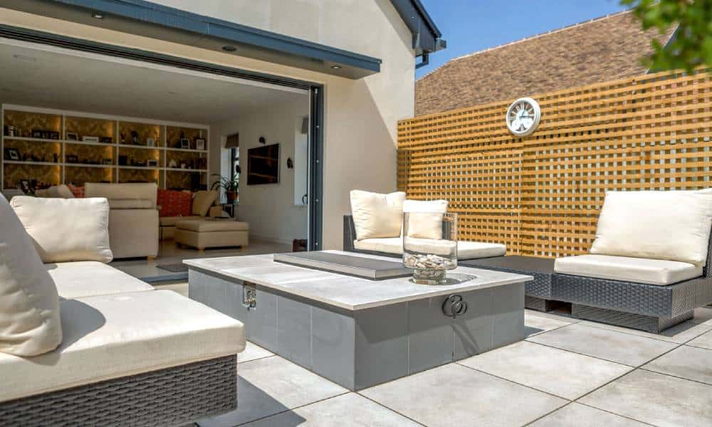 Sunlit patio with modern outdoor furniture and open living room.