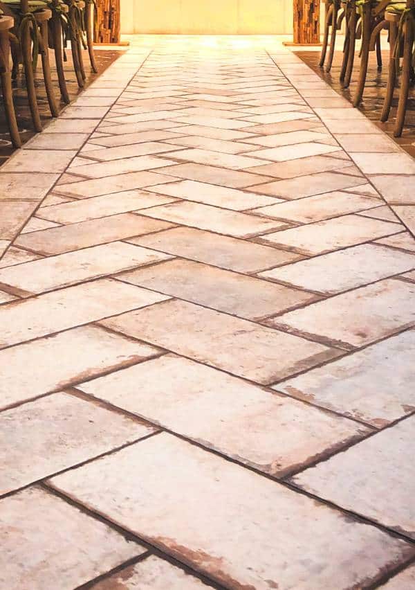 Paved outdoor pathway with warm lighting and stacked chairs.