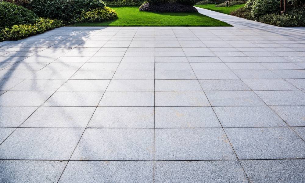 Paved walkway with shadows in a landscaped garden.