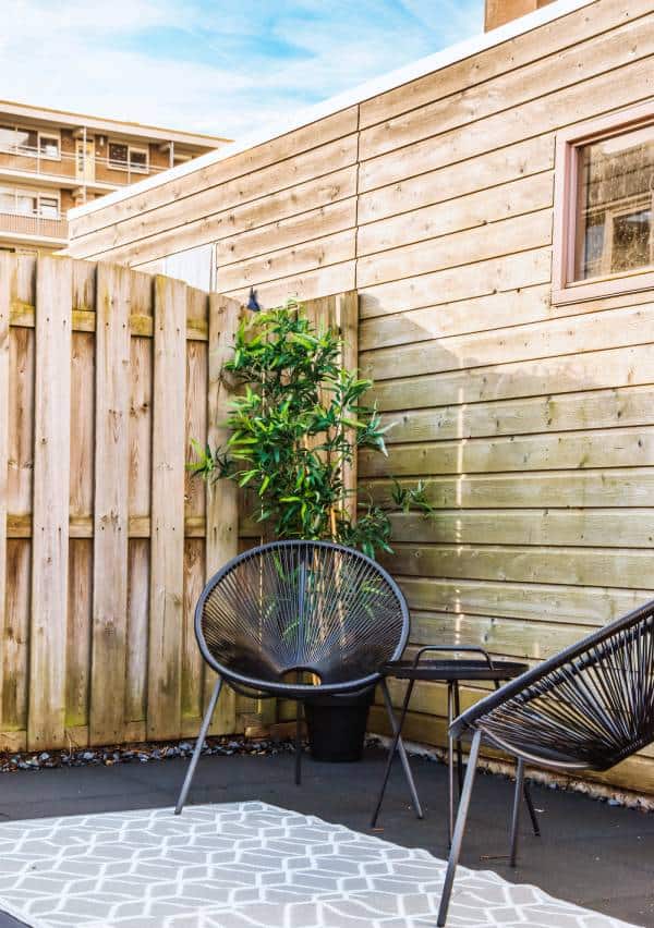 Cosy garden patio with modern seating and wooden fence.