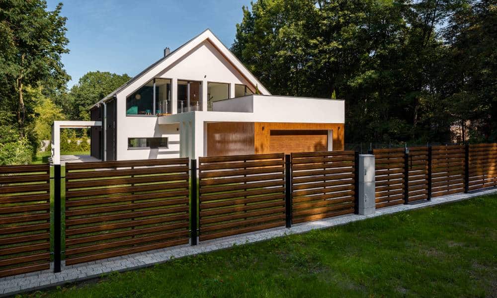 Modern house with wooden fence and greenery.